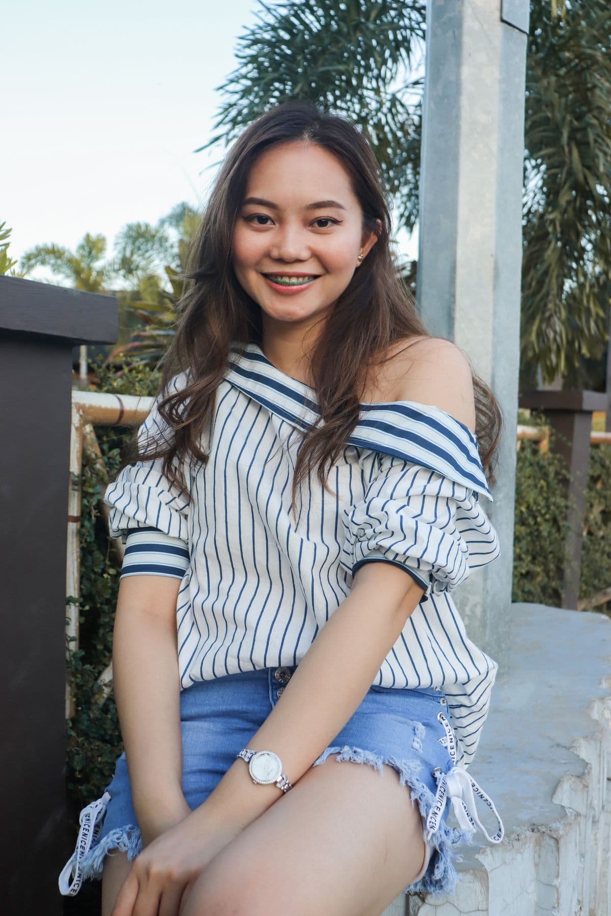 An adult smiling confidently outdoors