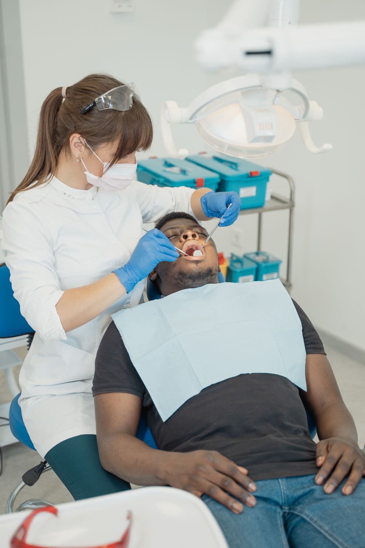 An orthodontist examining a patient's teeth with dental tools